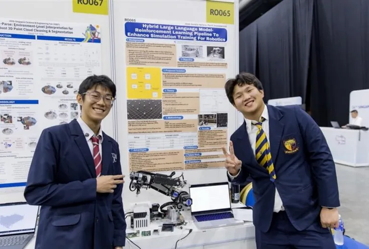 The founders at SSEF 2026 with their poster and robotic-arm prototype